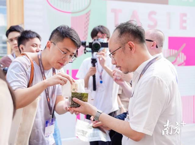 　　今年5月底，百农社国际有限公司参加了香港贸易发展局在深圳举办的“港·潮流”购物节，首次把“华御结”日式饭团带到内地市场。马国怡（右）正在邀请顾客品尝日式饭团。