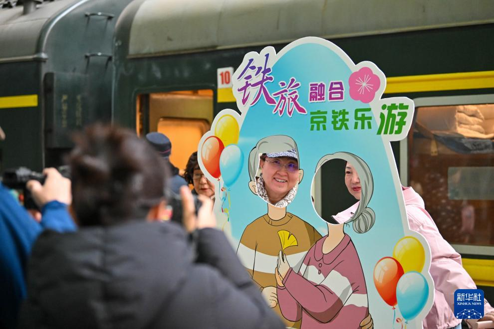 3月15日，在天津站站台，银发族游客在“京铁乐游”号银发旅游列车发车前拍照留念。新华社记者 孙凡越 摄