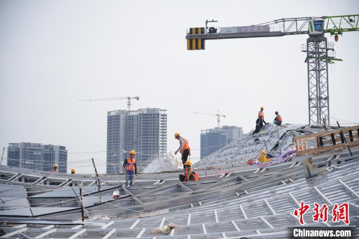 建设者们忙于幕墙工程、金属屋面、机电安装、精装修施工。记者 韦杰夫 摄